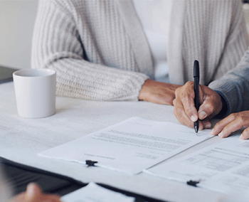 A man signing a contract with a witness